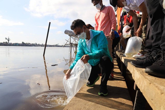 Wisatawan menyaksikan ritual tolak bala di tepian Sungai Kapuas