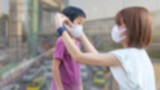Anak dan ibu gunakan masker untuk lindungi diri dari polusi udara.