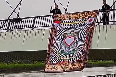 Pemuda Indonesia membentangkan spanduk PSHT Madiun