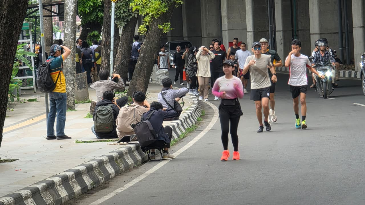 Saat pelari dan fotografer yang mengerubung