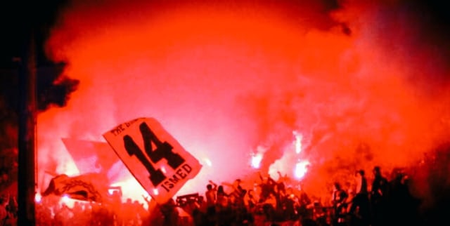 The Jakmania menyalakan flare dalam pertandingan. (Foto: Twitter @Ultras_Sector5)