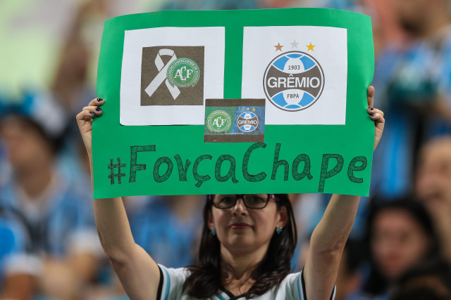 Seorang pendukung Gremio membentanngkan poster dukungan terhadap Chapecoense. (Foto: Buda Mendes)