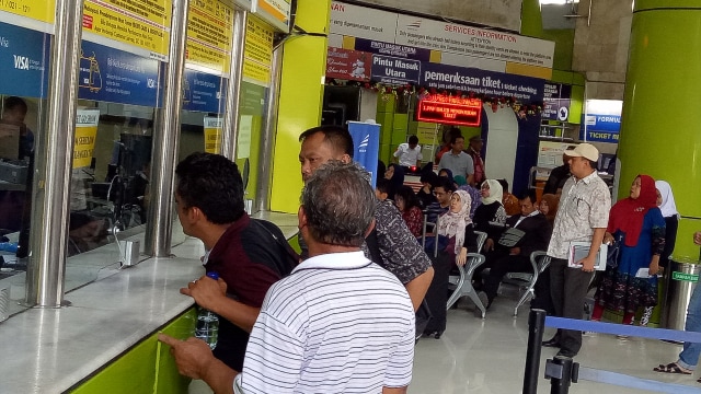 Penumpang yang sedang mengantri tiket di loket. (Foto: Mustaqim Amna/kumparan)