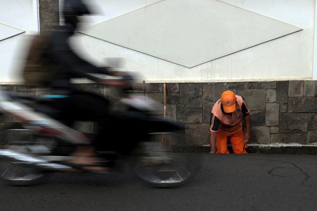 Pekerja Petugas Pelayanan Prasarana dan Sarana Umum (PPSU) membersihkan got. (Foto: Fanny Kusumawardhani/kumparan)