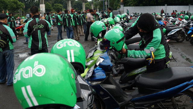 Seorang pengemudi sedang menaruh helm. Foto: Aditia Noviansyah/kumparan