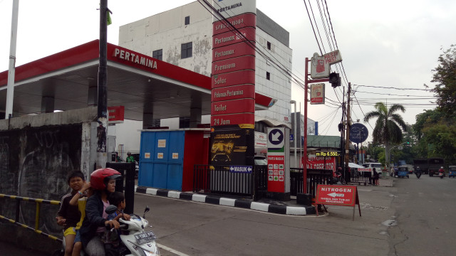 Seorang pengendara lewat di samping SPBU. (Foto: Wiji Nurhayat/kumparan)