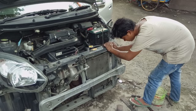 Pegawai Ketok Magic memperbaiki sebuah mobil (Foto: Mustaqim Amna/kumparan)