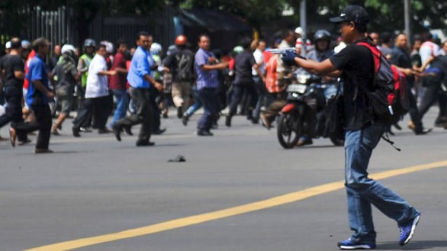 Bom Thamrin; teroris menodongkan pistol ke massa. (Foto: Veri Sanovri/Reuters)