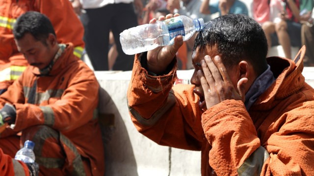 Petugas damkar membasuh wajahnya. (Foto: Fanny Kusumawardhani/kumparan)