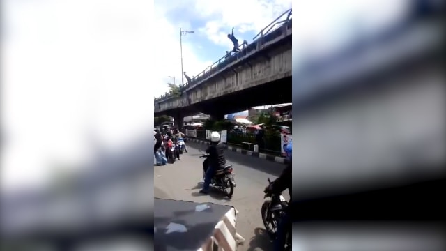 Seorang pria terjun dari jembatan layang. (Foto: Screenshot Youtube.)