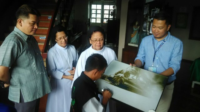 Ridwan menandatangani hasil karyanya. (Foto: Kevin Kurnianto/kumparan)