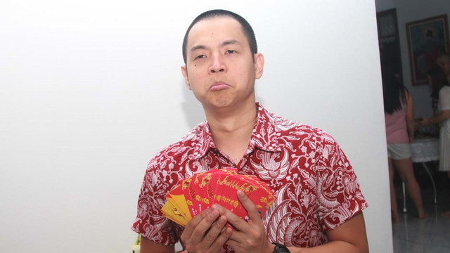 Ernest pamer angpau. (Foto: Munady Widjaja/kumparan)