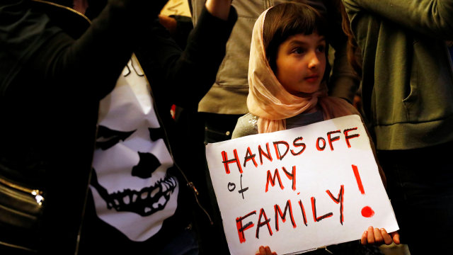 Seorang anak membawa atrbut menentang Trump (Foto: Patrick Fallon/Reuters)