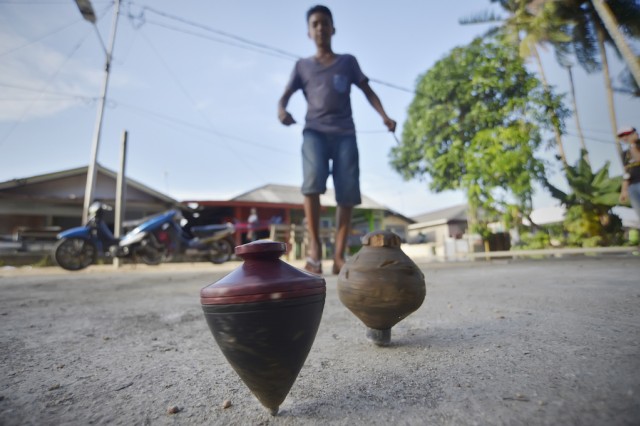 Gasing dimainkan anak-anak dan dewasa (Foto: Yudhi Mahatma/Antara Foto)