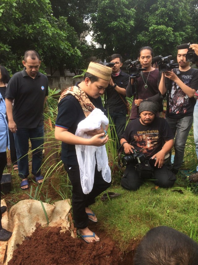 Bekti menggendong jasad anaknya untuk dimakamkan. (Foto: Yurika Kencana/kumparan)