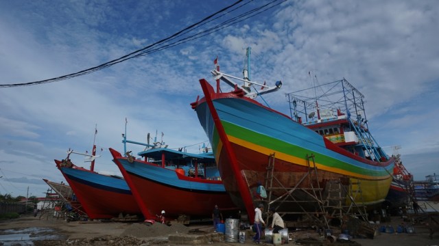 Nelayan sedang mengecat perahunya. (Foto: Aditia Noviansyah/kumparan)