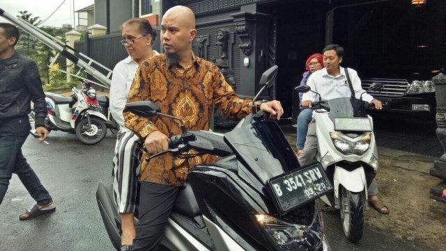 Ahmad Dhani menuju TPS dengan mengendarai motor. (Foto: Prabarini Kartika/kumparan)