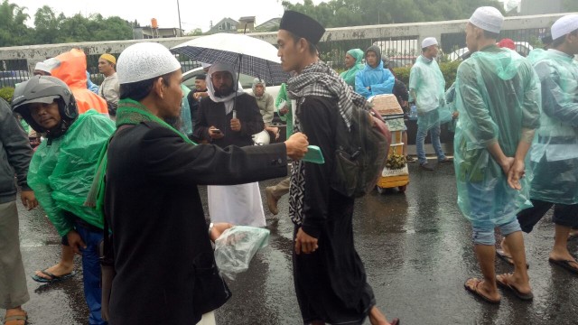 Ahmad Hanafi bagi jas hujan dan tolak angin (Foto: Ela/kumparan)