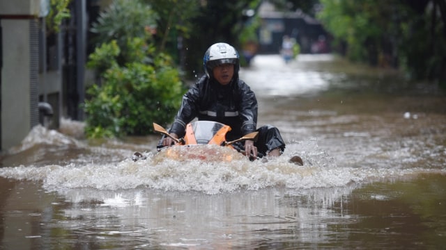 Pengendara motor melewati banjir.  Foto: Akbar Nugroho Gumay/Antara