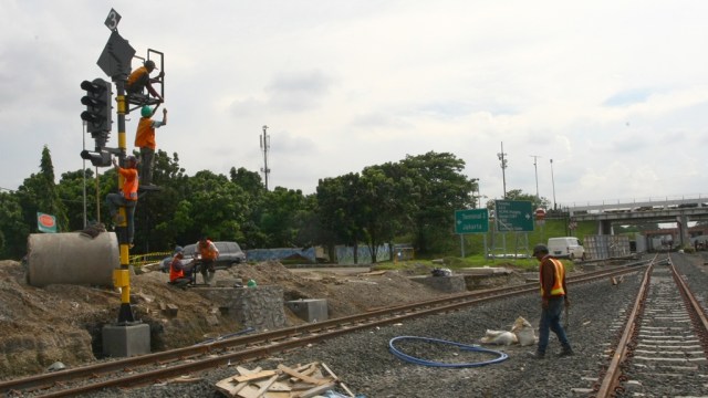 Pekerja memasang lampu persinyalan kereta. (Foto: Antara/Muhammad Iqbal)