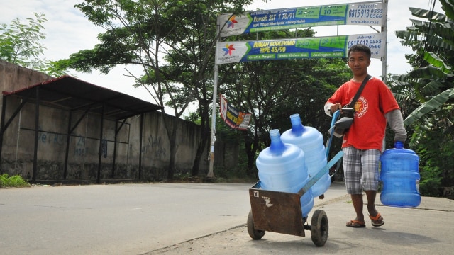 Ridwan sedang mengantarkan galon air mineral. (Foto: Kevin Kurnianto/kumparan)