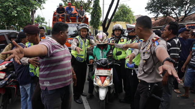 Polisi mengamankan sopir gojek yang terancam. (Foto: Lucky R/ANTARA)
