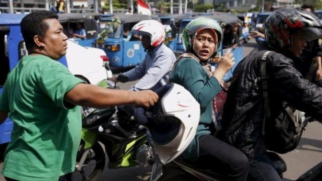 Penumpang ojek online menerima amarah sopir bajaj (Foto: Darren Whiteside/Reuters)