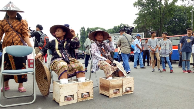 Petani Rembang duduk dengan kaki dicor semen. (Foto: David Pratama/kumparan)
