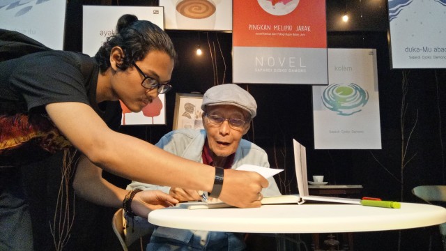 Sapardi Djoko Damono mendatangani buku. (Foto: Prabarini Kartika/kumparan)