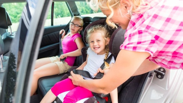 Ibu yang mengaitkan sabuk pengamanan anaknya (Foto: Thinkstock)