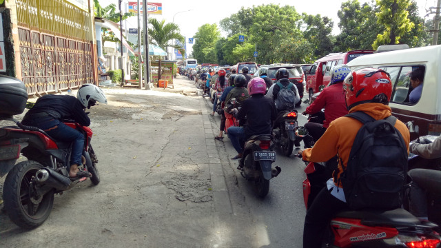 Seorang pengendara motor tidur saat hadapi macet. (Foto: Utomo Priyambodo/kumparan)