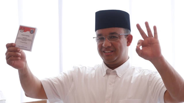 Anies menunjukan surat suara usai mencoblos. (Foto: Reuters/Beawiharta)