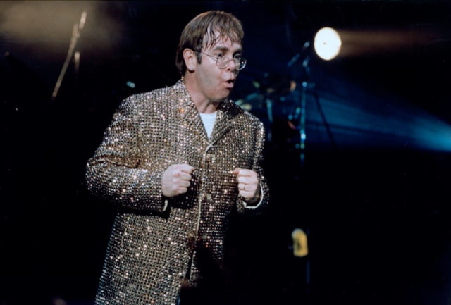 Elton nyentrik dengan kostum emas berkilauan, 1995 (Foto: eltonjohn.com)