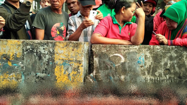 Warga menonton serpihan tubuh diduga pelaku bom (Foto: Marcia Audita/kumparan)