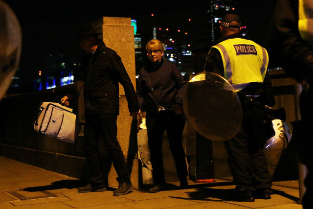 Polisi mengolah lokasi teror (Foto: Neil Hall/Reuters)