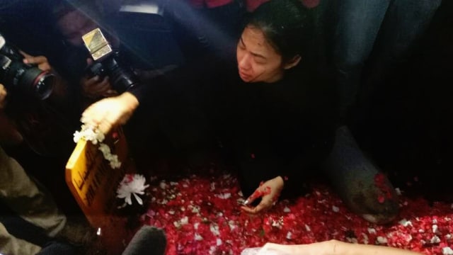 Dela adik Jupe menangis di kuburan Jupe (Foto: DN. Mustika Sari/kumparan)
