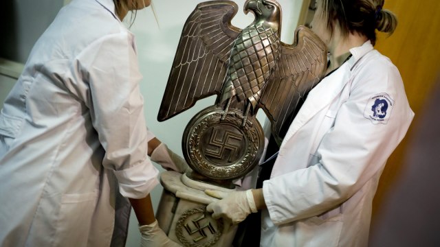 Petugas membawa patung Nazi Foto: AP/Natacha Pisarenko