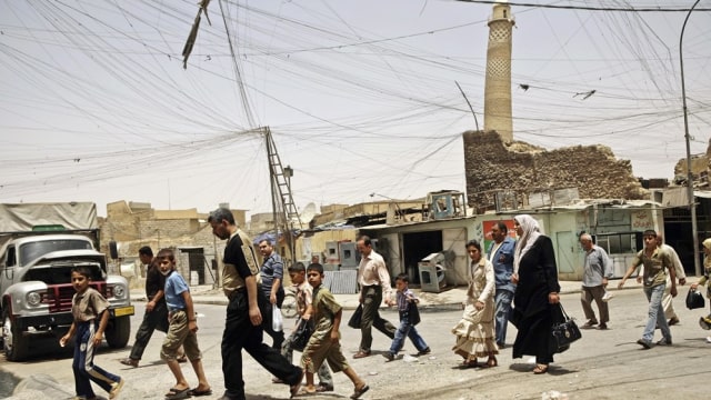 Warga Mosul melintas di depan Masjid al-Nuri (Foto: AP Photo/Maya Alleruzzo)