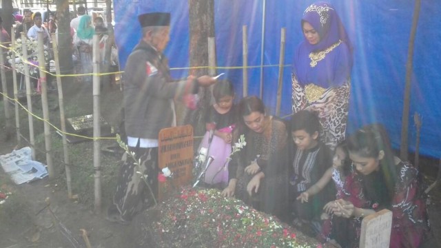 Keluarga nyekar ke makam Jupe. (Foto: Caroline Peramantie/kumparan)