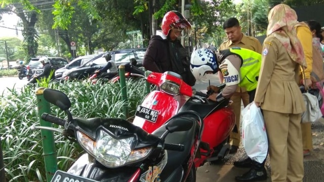 Tilang pengendara motor yang melintasi trotoar. (Foto: Twitter @TMCPoldaMetro)
