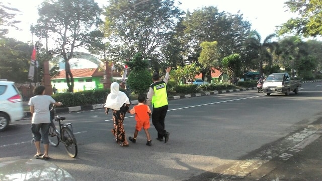 Anggota Polsek Candi Polresta Sidoarjo Bantu Sebrangkan Anak Sekolah