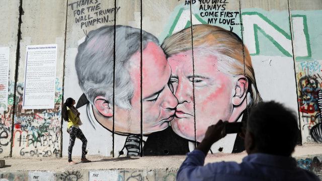 Turis berfoto di depan mural Trump-Netanyahu (Foto: REUTERS/Ammar Awad)