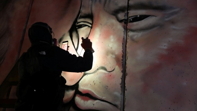 Lushsux menggambar mural di Tembok Ratapan (Foto: REUTERS/Ammar Awad )