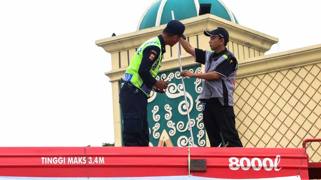 Petugas mengecek pasokan BBM di SPBU depan masjid Rest Area KM 57 Foto: Puti Cinintya Arie Safitri /kumparan