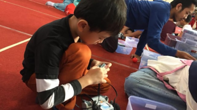Sedang mengajarkan anak kecil merakit robot (Foto: amara Anastasia Wijaya/kumparan)