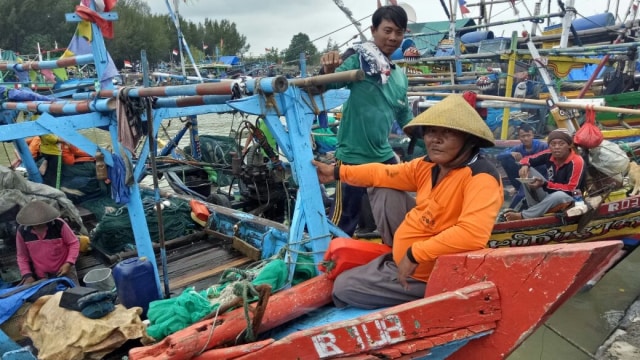 Taat (baju oranye), nelayan di TPI Larangan Tegal (Foto: Angga Sukmawijaya/kumparan)