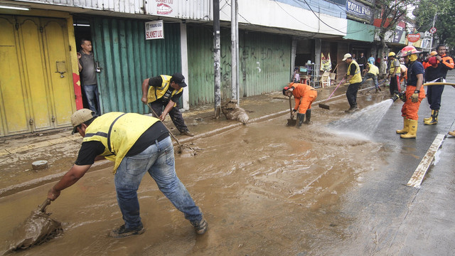 Bersihkan lumpur pasca banjir Foto: ANTARA FOTO/Dhemas Reviyanto