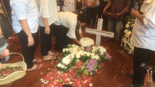 Istri dan anak tabur bunga di makam Advent Bangun (Foto: Regina KR/kumparan)