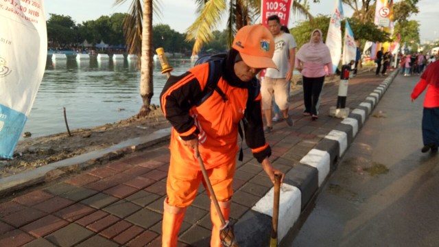 Sarwini membersihkan area Danau Sunter (Foto: Ochi/kumparan)