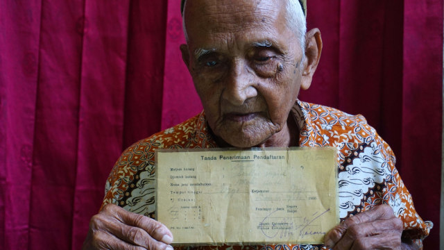 Nyak Sandang memegang surat obligasi. (Foto: Zuhri Noviandi/kumparan)